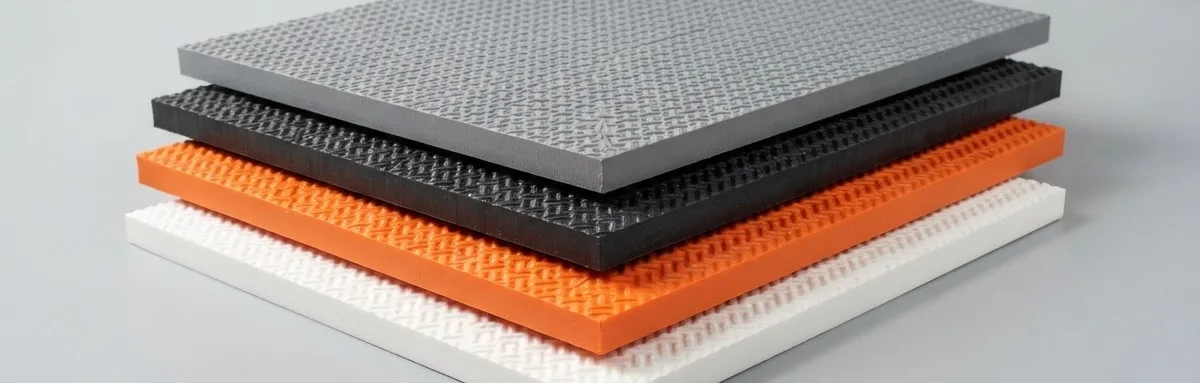 Stack of embossed plastic sheets in black, orange and white